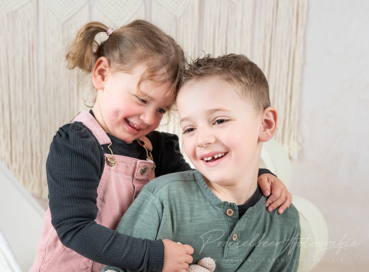 Kindergartenfotografie Donau-Ries – Geschwister lachen und umarmen sich beim Fotoshooting