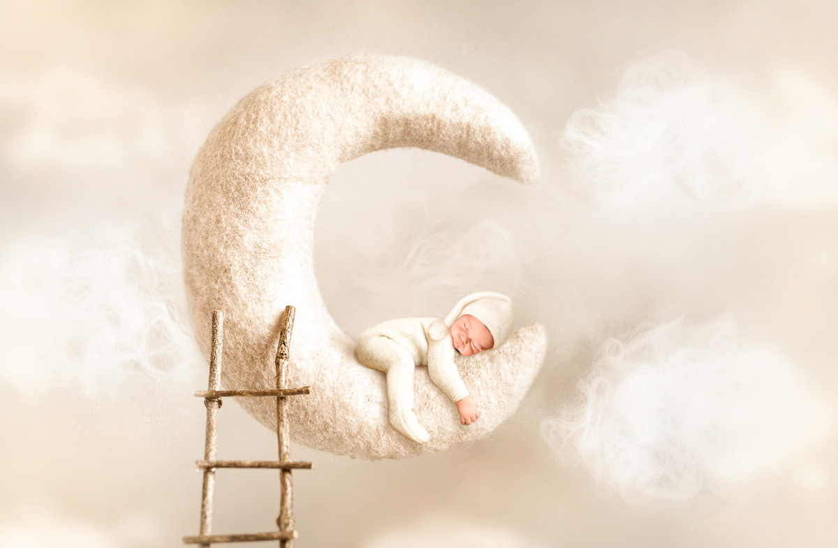Künstlerisches Newborn-Shooting im Donau-Ries – Baby schläft auf Mondsichel mit Wolken und Leiter